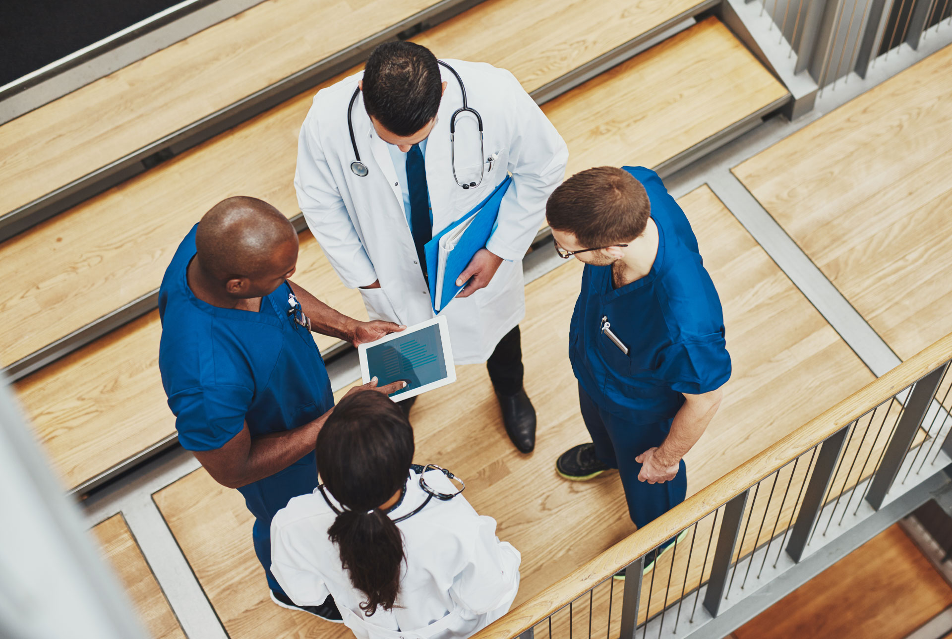 Four Doctors Consulting over a Tablet